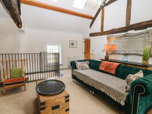 een woonkamer met een groene bank en een spiegel bij Plas Glan Yr Afon in Abergele +62 foto's