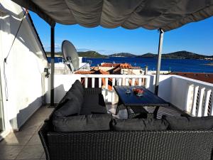 eine Terrasse mit einem Tisch und Stühlen auf dem Balkon in der Unterkunft Kuća Get in Betina