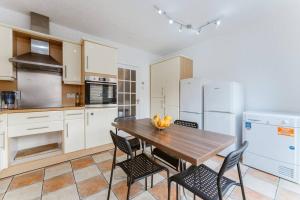 a kitchen with a wooden table and chairs at Comfortable Double Room for Your London Getaway in London