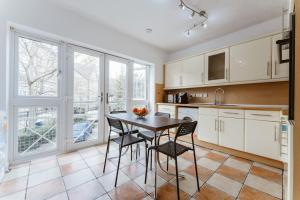 a kitchen with white cabinets and a table and chairs at Comfortable Double Room for Your London Getaway in London