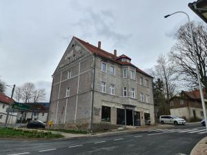 um velho edifício de tijolos na esquina de uma rua em Apartament Ptasia Ostoja - 5D Apartamenty em Świeradów-Zdrój