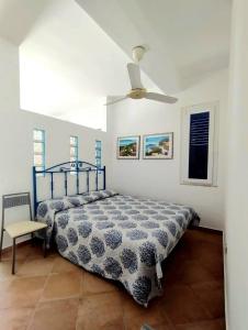 1 dormitorio con 1 cama y ventilador de techo en Casa delle Sirene en Isola delle Femmine