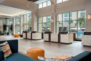 - un hall d'un hôtel avec des tables et des chaises dans l'établissement SpringHill Suites by Marriott Orlando Theme Parks Lake Buena Vista, à Orlando