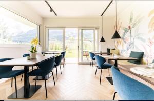 a restaurant with tables and chairs and a large window at Pitla Cuna Eco Relais in Terlano