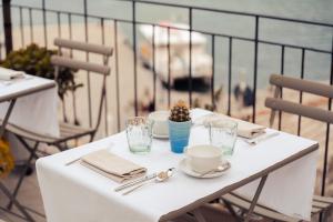 a white table with plates and cups on a balcony at Torre a Mare Porto Venere in Portovenere