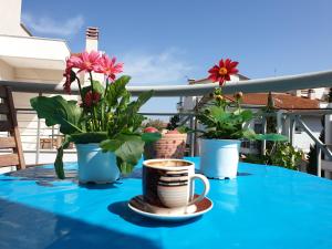 a table with two cups of coffee and flowers on it at Iliana House in Neoi Epivates