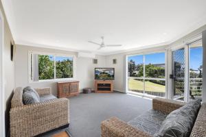 a living room with two couches and a tv at 5 Brolga Place Peregian Beach in Peregian Beach