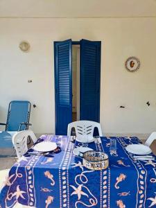 a table with a blue and white table cloth on it at Casa delle Sirene in Isola delle Femmine