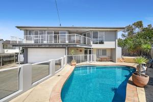 a house with a swimming pool in front of a house at 5 Brolga Place Peregian Beach in Peregian Beach