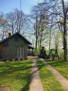 einen Weg, der zu einem Steinhaus in einem Park führt in der Unterkunft Planinska kuca Steki Bukulja in Aranđelovac