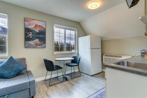 Cozy 1 bedroom Apartment Canmore / Banff في كانمور: مطبخ مع ثلاجة وطاولة وكراسي