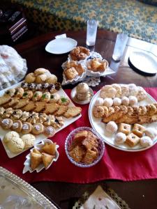 a table topped with plates of pastries and pies at Meknès adrae in Meknès