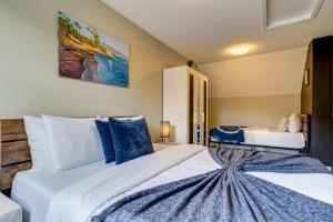a bedroom with a large white bed with blue pillows at Cozy 1 bedroom Apartment Canmore / Banff in Canmore