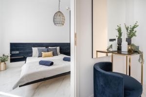 a bedroom with a bed and a blue chair at Basilica Presidential panorama suits in Budapest