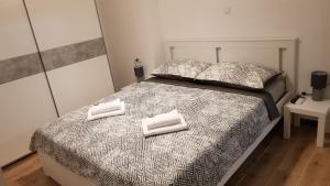 een slaapkamer met een bed met twee handdoeken erop bij KaLea Pula Center in Pula