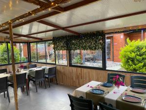 a dining room with tables and chairs and windows at Karaöz Ada Bungalows & Villa in Karaoz