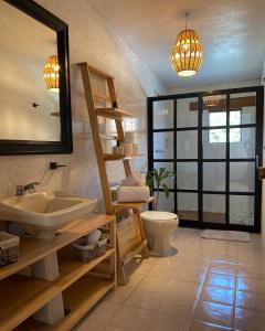 a bathroom with a sink and a toilet and a mirror at Casa Mayo B&B in Oaxaca City