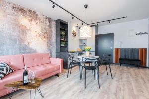 sala de estar con sofá rosa y mesa en Platinum Premium Apartment, en Grudziądz