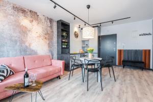 uma sala de estar com um sofá rosa e uma mesa em Platinum Premium Apartment em Grudziądz