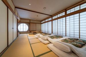 una fila di letti in una stanza con finestre di Ryokan Ryokufuso a Kyoto