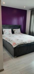 1 cama en un dormitorio con pared púrpura en Apartman Maksimir with free parking en Zagreb