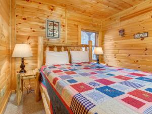 1 dormitorio con 1 cama en una cabaña de madera en Truly Blessed, 3 Bedrooms, Hot Tub, Sleeps 10 en Gatlinburg