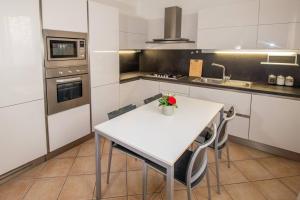 una cocina con una mesa blanca y algunas sillas en Stefano Apartments Padova Spacious,with parking, en Mestrino