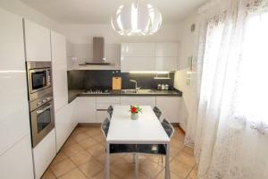 cocina con mesa blanca y fogones en Stefano Apartments Padova Spacious,with parking, en Mestrino