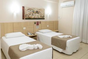 um quarto de hotel com duas camas com toalhas em San Juan Tour em Foz do Iguaçu