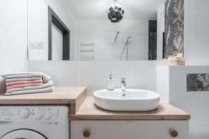 ein Badezimmer mit Waschbecken und Waschmaschine in der Unterkunft Platinum Premium Apartment in Graudenz + 18 Fotos