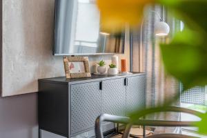 ein schwarzer Schrank mit einem Spiegel und Pflanzen darauf in der Unterkunft Platinum Premium Apartment in Graudenz