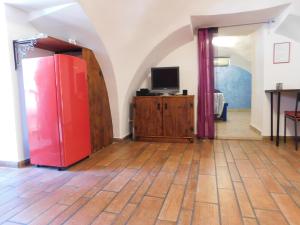 Cette chambre dispose d'un réfrigérateur rouge et d'une télévision. dans l'établissement Partenope Magica, à Naples