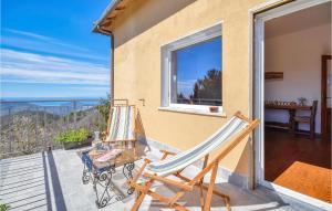 un patio con 2 sillas y una mesa en el balcón en Nice Home In Castiglione Chiavarese With Kitchen, en Castiglione Chiavarese