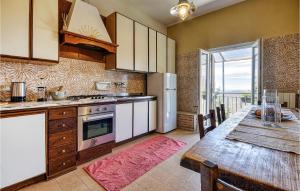 cocina con mesa de madera y comedor en Nice Home In Castiglione Chiavarese With Kitchen, en Castiglione Chiavarese