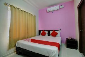 a bedroom with a bed with a pink wall at Flagship Manu Residency Near Ascendas Park Square Mall in Bangalore