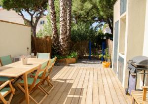 patio ze stołem, krzesłami i sprzętem do grillowania w obiekcie La Capte, A 2min de la mer, Terrasse-Wifi-Parking gratuit w Hyères