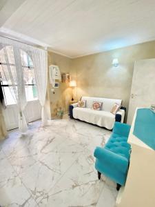 een woonkamer met een bank en een blauwe stoel bij Ortigia Dreaming in Siracusa