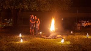 a group of people standing in front of a fire at Big Game - Yala by Eco Team in Yala