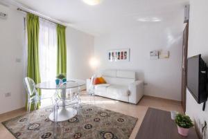 a living room with a white couch and a glass table at The Caves Apartments in St. Julianʼs