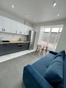 ein Wohnzimmer mit einem blauen Sofa und einer Küche in der Unterkunft Apartment for you in Iwano-Frankiwsk