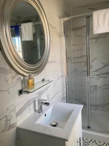 a white bathroom with a sink and a mirror at Paragon Home in Ramsgate