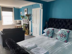 a blue bedroom with a bed and a couch at Paragon Home in Ramsgate