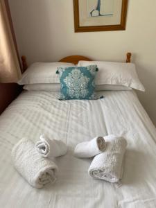 Una cama con toallas y almohadas. en Village centre apartment en Lahinch