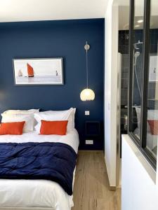 a bedroom with blue walls and a bed with orange pillows at La Cabane des Pêcheurs in Quiberon