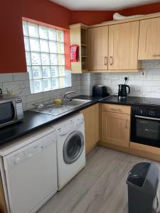 a kitchen with a washing machine and a dishwasher at Village centre apartment in Lahinch