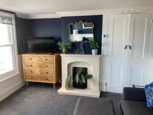 a living room with a fireplace and a television at Paragon Home in Ramsgate