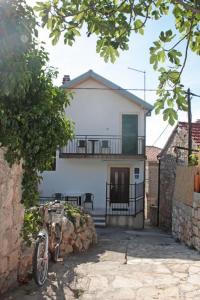 una casa con una bicicleta estacionada frente a ella en Holiday home Marina-renovated house in city center, en Rogoznica