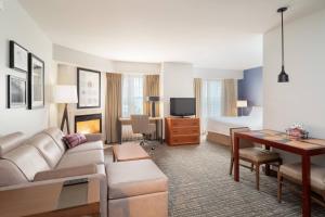 a hotel room with a couch and a desk and a bed at Residence Inn New Bedford Dartmouth in North Dartmouth