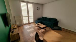 salon z zieloną kanapą i stołem w obiekcie Apartament w Centrum w mieście Częstochowa