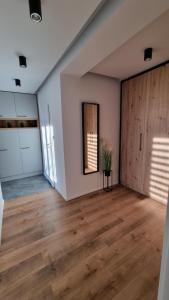 an empty room with wooden floors and a door at Apartament w Centrum in Częstochowa